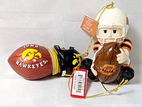 Both NCAA football ornaments with tags