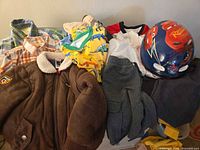 Full lot showing jacket, shirts, pajamas, helmet, pants, mittens