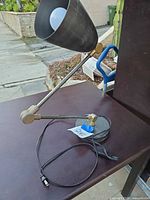 Full view of adjustable metal desk lamp showing cone shade, arm sections, base and power cord