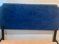 Front view of navy blue crushed velvet headboard with nailhead trim