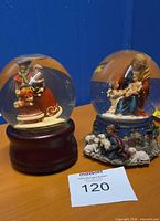 Both musical snow globes side by side showing overall appearance