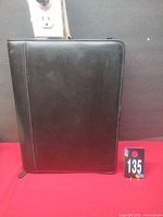 Front view of closed black Bodenschatz binder standing upright