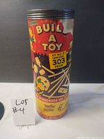 Front of cylindrical container showing brand, kit number and piece count