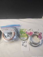 Group shot of all wire items: zip bag with three coils, two Ashland coils, one Flex-Rite spool