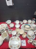 Full lot overview showing mixed china pieces on red cloth