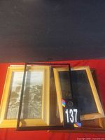 Stack of wooden and glass-front frames with auction tag