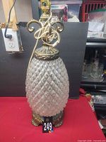 Full view of the glass pineapple lamp on red cloth showing overall design