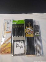 Four unopened chopstick packs: Tong-Ya wood, EMF stainless steel, two melamine packs