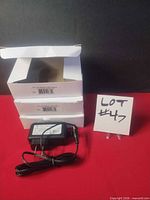 Three white product boxes stacked with one adapter shown