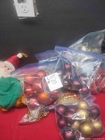 Stockings, bags of red, burgundy and gold ball ornaments, gold bead garland