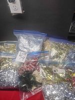 Multiple ziplock bags filled with assorted metallic tinsel garland