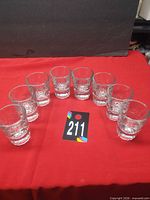 All eight clear shot glasses arranged in arc