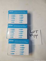 Front view of three Magna scalpel blade boxes showing blade size illustrations and counts