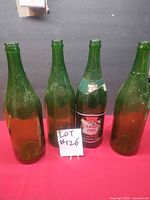 Four green Canada Dry bottles front view