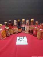 Group shot of all 11 miniature liquor bottles on red cloth