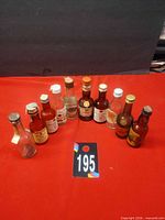 Group shot of ten miniature bottles arranged in arc on red surface