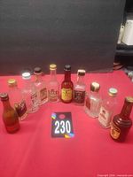 All twelve miniature bottles arranged upright on red surface