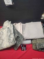 Stack of folded jeans showing snake print, grey, olive and other colours