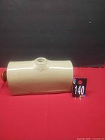 Side view of stoneware bottle showing filler neck and glaze