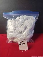 Full bag of white cotton gloves in zip-top bag