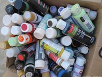 Open box filled with many small acrylic paint bottles