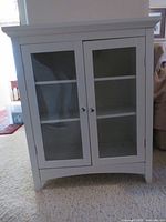 Front view of white cabinet with two glass doors closed