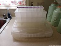 Four stacked clear storage containers on countertop