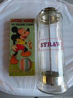 Straw dispenser and Mickey Mouse straws side by side