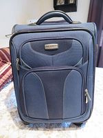 Front view showing brand badge, zip pockets, handle