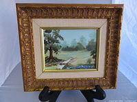 Frontal view of framed painting on stand