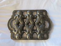 front view of cast iron mold showing six gingerbread figures