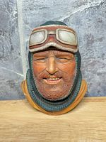 Front view of aviator bust showing facial detail, goggles and hood