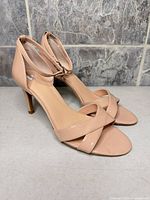 Left side view of both sandals showing patent finish, heel, straps