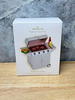 Front of Season's Grillings ornament box showing grill illustration and Hallmark Keepsake branding