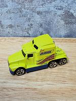 Left front view of yellow-blue Big Rig cab showing decals and wheel style