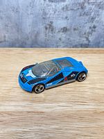 Left front view showing blue body, decals, wheels