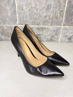 Side view of both pumps showing leather upper and heel height