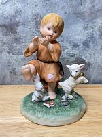 Front view of figurine showing boy, lamb, rabbit and base