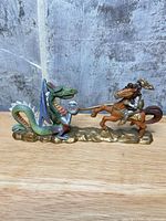 Left profile showing overall sculpt of knight on horse confronting dragon