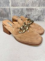 Angled view of tan suede chain mules