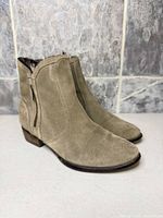 Side view of both suede ankle boots showing uppers, heels and color