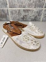 Pair of TF STAR slingback espadrille flats, top view showing embroidery and tag attached