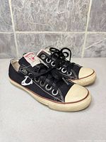 Left side view of both sneakers showing logo, canvas condition and soles