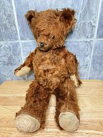 Front view of seated vintage mohair teddy bear showing overall wear