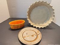 Group shot of pie dish, plate, orange oval bowl
