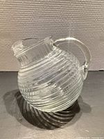 Profile view of clear spiral-ribbed glass pitcher