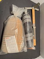 Ham and seam roll in plastic next to hem gauge