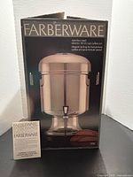 Front of retail box showing Farberware 18-55 cup stainless electric coffee urn and instruction booklet