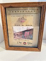 Front view of framed Berlin Wall fragment and certificate