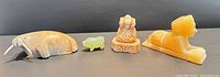 All four stone figurines lined up for scale and material view